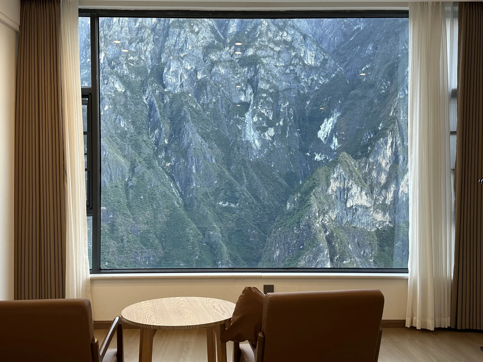 Daytime view of the gorge from the guest room window, with a small table and chairs