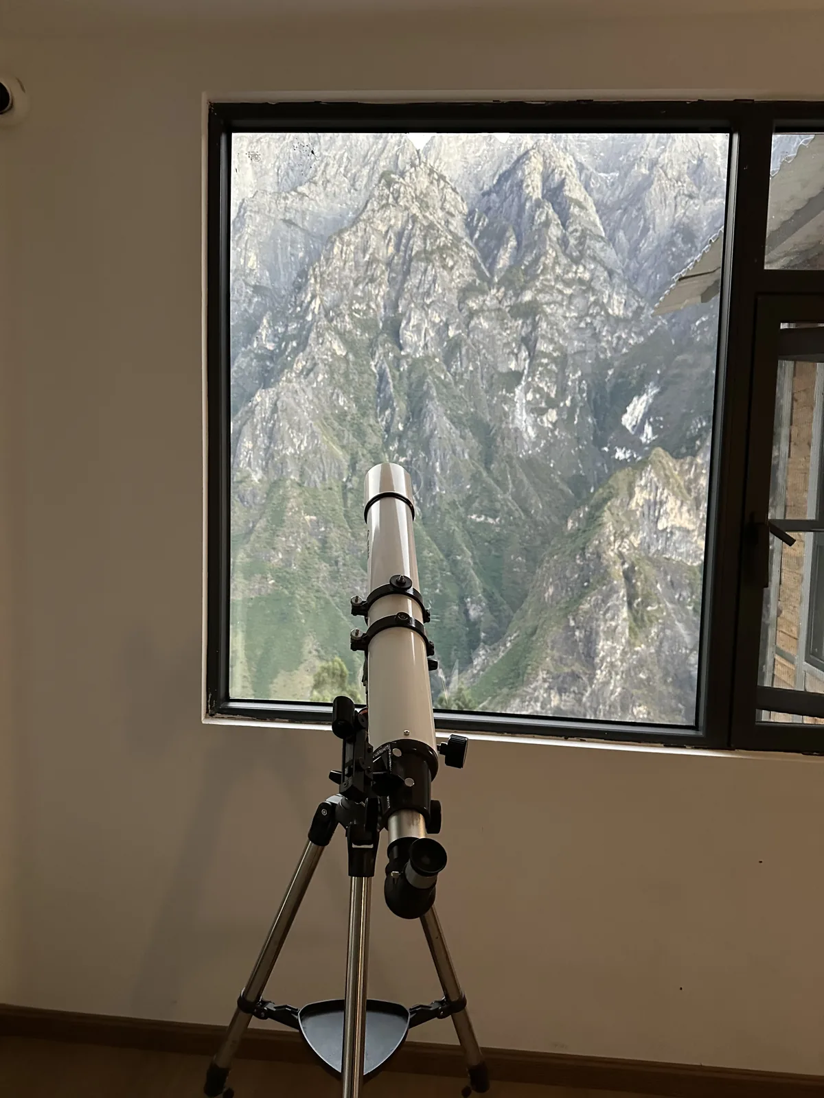 A telescope in the corridor pointed at the window and the gorge beyond